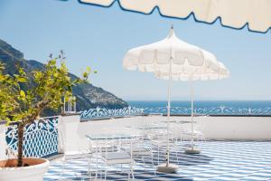 a table and chairs on a balcony with the ocean at Hotel Conca d'Oro in Positano