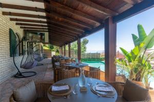 a patio with tables and chairs and a pool at Corfelia Seaview Suites in Ipsos