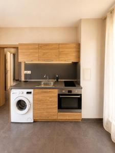 a kitchen with a sink and a washing machine at Maxi 2 parking included in Sofia