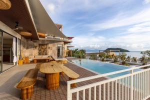 an outdoor deck with a wooden bench and a swimming pool at Villa Bodhi in Ko Phangan