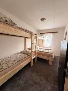two bunk beds in a room with a window at Horský dům in Jáchymov