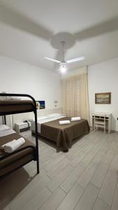 a bedroom with two beds and a ceiling fan at Hotel Primula in Lido di Savio