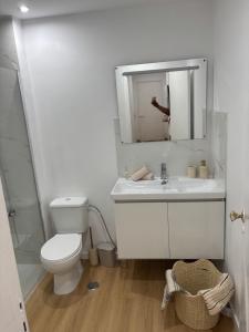 a bathroom with a toilet and a sink and a mirror at Casa Borges in Quelfes +7 photos