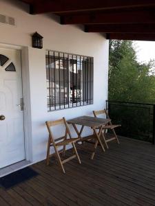 a picnic table and two chairs on a porch at Canoas Apart in Colón