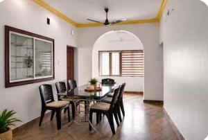 a dining room with a table and chairs at Kandass Homestay in Trichūr