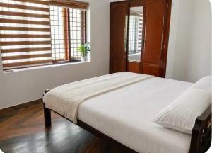 a bedroom with a bed and a window at Kandass Homestay in Trichūr