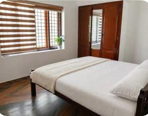 a bedroom with a bed and a window at Kandass Homestay in Trichūr +2 photos