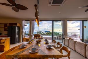 a dining room with a large wooden table with chairs at Villa Bodhi in Ko Phangan