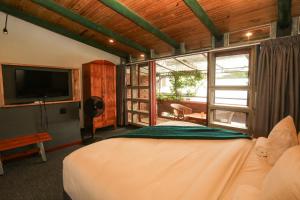 a bedroom with a bed and a flat screen tv at Asali Lodge in East London