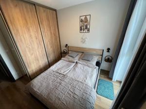 a bedroom with a bed with a wooden headboard at Apartament Calisia in Kalisz