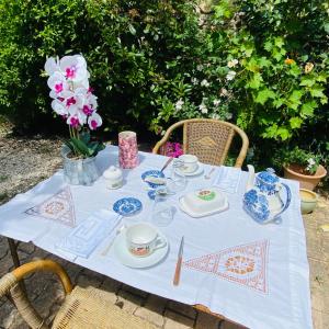 a table with blue and white dishes and flowers on it at La Maison aux coquillages in Portel-des-Corbières