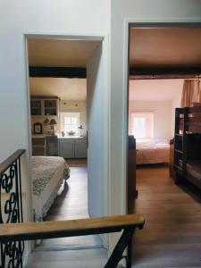 a bedroom with two beds and a kitchen in the background at La Maison aux coquillages in Portel-des-Corbières