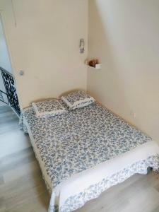 a bed in a room with two pillows on it at La Maison aux coquillages in Portel-des-Corbières +18 photos