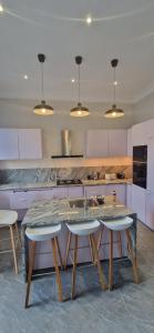 a kitchen with a marble table and four chairs at The white house in Douala