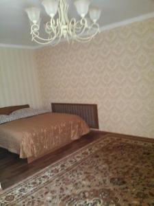 ビシュケクにあるGuest House Domashniy Uyutのベッド2台とシャンデリアのある寝室