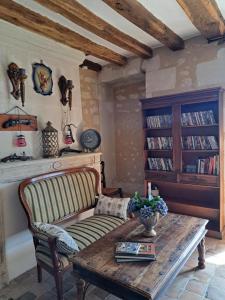 a living room with a couch and a wooden table at Chambre d'hotes de l'Ecu in Preuilly-sur-Claise