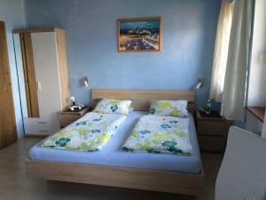a bedroom with two beds with blue walls at Pension Erlerhof Chez Karin in Tulfes