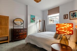 a bedroom with a bed with a lamp and a dresser at High Street Hideaway Cheltenham in Cheltenham