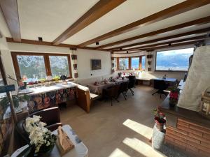 a large room with tables and chairs and windows at Pension Erlerhof Chez Karin in Tulfes