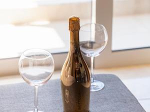 a bottle of wine and two wine glasses on a table at Bill Apartments in Patra +47 photos