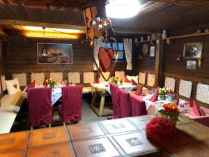 a dining room with tables and chairs with red chairs at Pension Erlerhof Chez Karin in Tulfes +45 photos