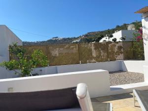 a balcony with a white bench and a fence at Villa Palmosa in Skala