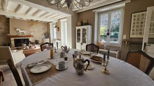 a dining room with a table with plates and utensils at L'Orée d'Ermenonville in Borest