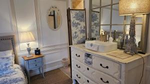 a bathroom with a sink and a mirror on a dresser at L'Orée d'Ermenonville in Borest