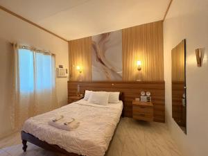 a bedroom with a bed and a painting on the wall at The Ivory Castle in Pooc