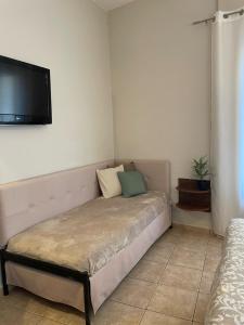 a bedroom with a bed with a flat screen tv on the wall at ΑΡΓΩ in Kala Nera