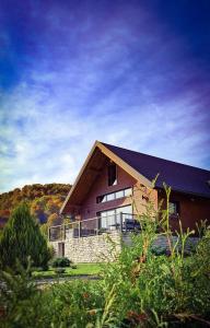 a house with a gambrel roof on top of it at Casa Kapusta, Hidden gem in nature, Swimming poll, Jacuzzi, Fire Pit in Ogulin