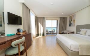 a hotel room with a bed and a desk and a television at Sunrise Solara Aqua park Resort in Hurghada