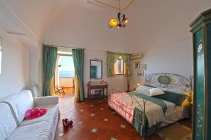 a bedroom with a bed and a couch at Casa Elena in Praiano