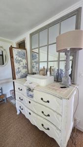 a white dresser with a sink and a lamp on it at L'Orée d'Ermenonville in Borest