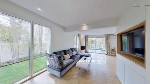 a living room with a couch and a flat screen tv at Host Villas LA TIRMANAISE Capbreton in Capbreton