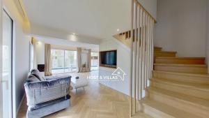 a living room with a staircase and a couch at Host Villas LA TIRMANAISE Capbreton in Capbreton +5 photos