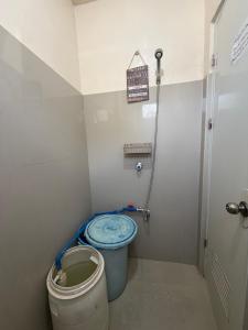 a small bathroom with a blue toilet and a bucket at Maria Kulafu Lodging House Pier site- Santa Clara office 2nd Floor in Cagba