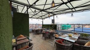 a restaurant with tables and chairs and a balcony at Hotel Janmabhumi in Pashupatināth