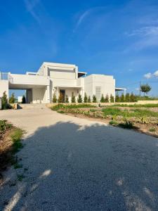 a white house with a road in front of it at Masseria l'Ulìa in Gallipoli