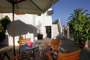 a patio with a table and chairs and an umbrella at Studios Akrogiali in Kyparissia