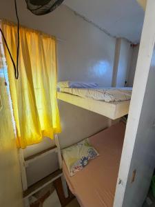 a small room with a bunk bed and a window at Maria Kulafu Lodging House Pier site- Santa Clara office 2nd Floor in Cagba