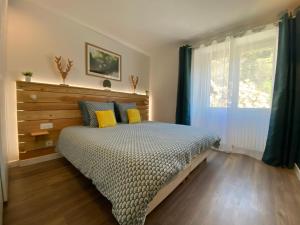 a bedroom with a bed with yellow pillows and a window at Ardeche2coeur in Marcols-les-Eaux