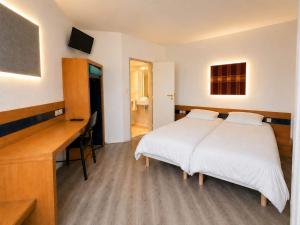 a bedroom with a bed and a desk with a computer at Mâcon Nord Hôtel, Ex Charme En Maconnais in Mâcon