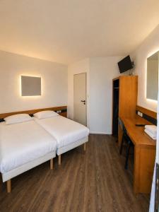 a hotel room with a bed and a desk at Mâcon Nord Hôtel, Ex Charme En Maconnais in Mâcon +13 photos