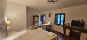 a room with a bed and a television and a clock at Poggio Cortese in Todi