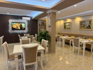a restaurant with tables and chairs and a tv at Villa Arben Elezi in Berat