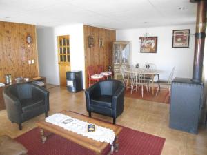 sala de estar con 2 sillas y mesa en Cabañas Rusticas en Coyhaique, en Coyhaique