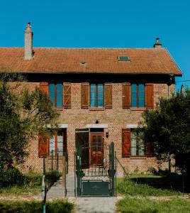 a brick house with a gate in front of it at La batisse du Champ Manneret Maison d'hôte Falaise - logement entier in Falaise