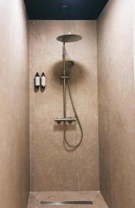 a shower in a bathroom with two bottles on the wall at B-ROOMS Bleisure Hotel - Lugano district in Manno