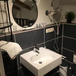 La salle de bains est pourvue d'un lavabo et d'un miroir. dans l'établissement Hotel B&B Bredl in der Villa Ballestrem, à Straubing